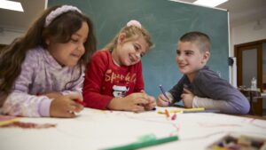 Infants participant al PROGRAMA +INFÀNCIA fent una activitat creativa en un espai educatiu