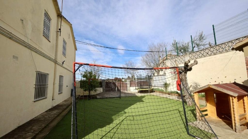 Pati exterior del CRAE Santa Agnès de REIR amb zona de joc, porteria i caseta de fusta